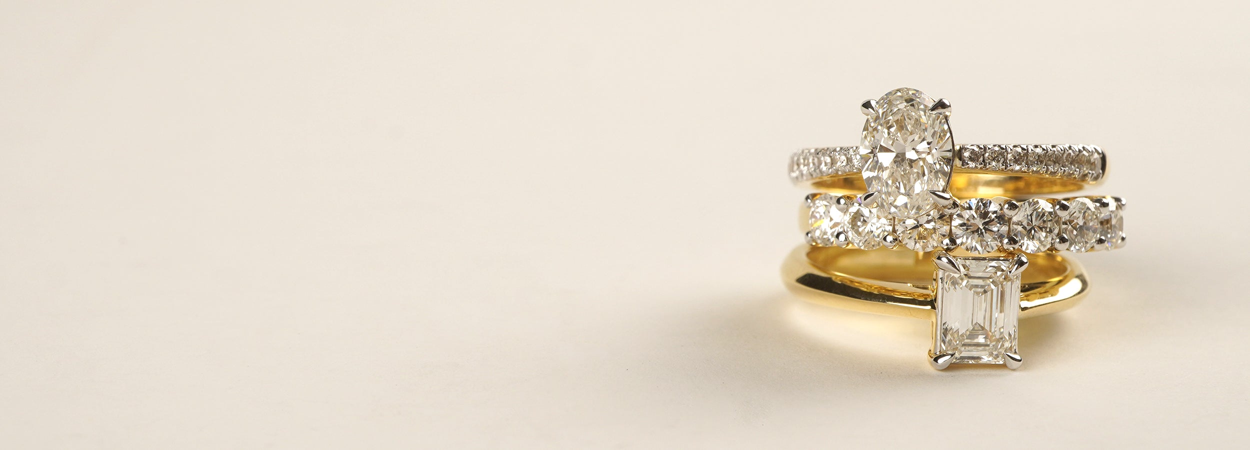 Gold ring with diamond accents on a beige background